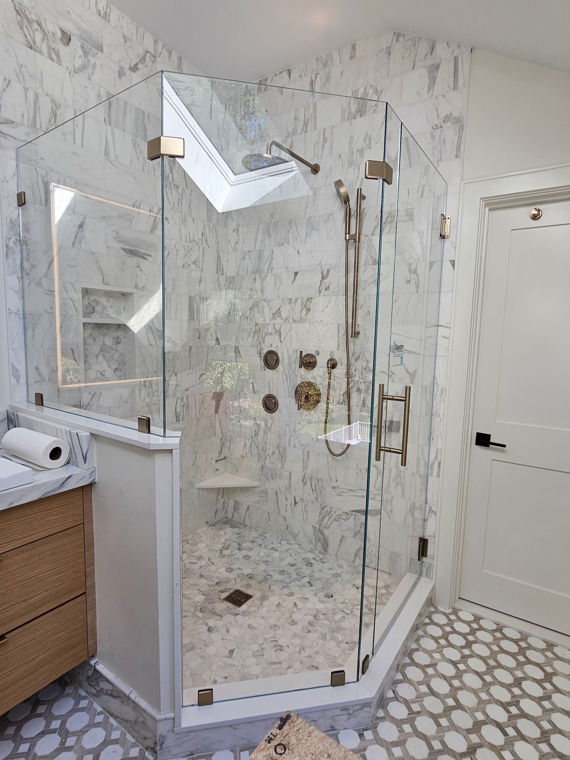 Bathroom with a large glass shower enclosure. Gray tile floor, light blue walls, a dark vanity, and a toilet.