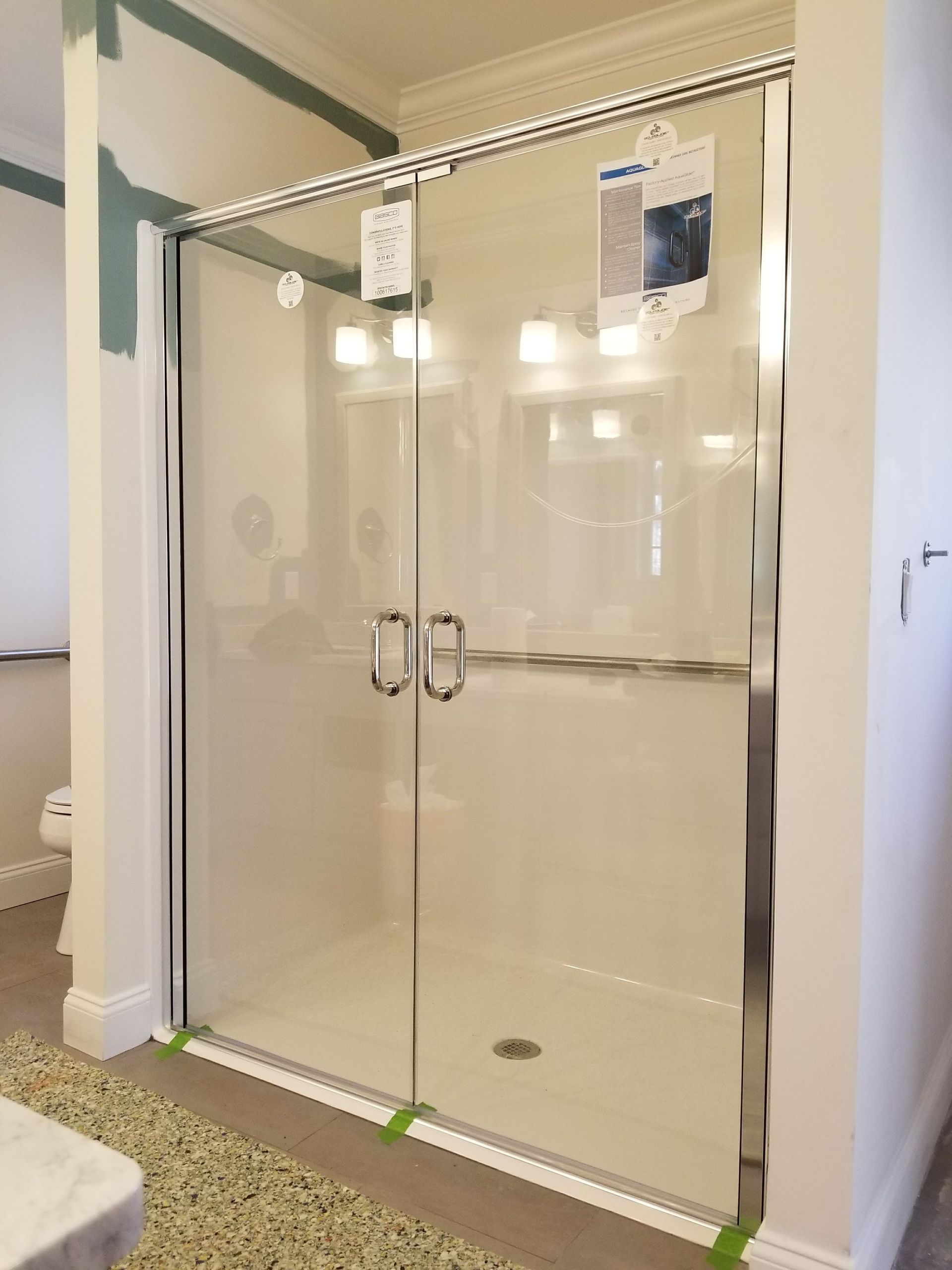 Glass shower enclosure with chrome hardware, installed in a bathroom.