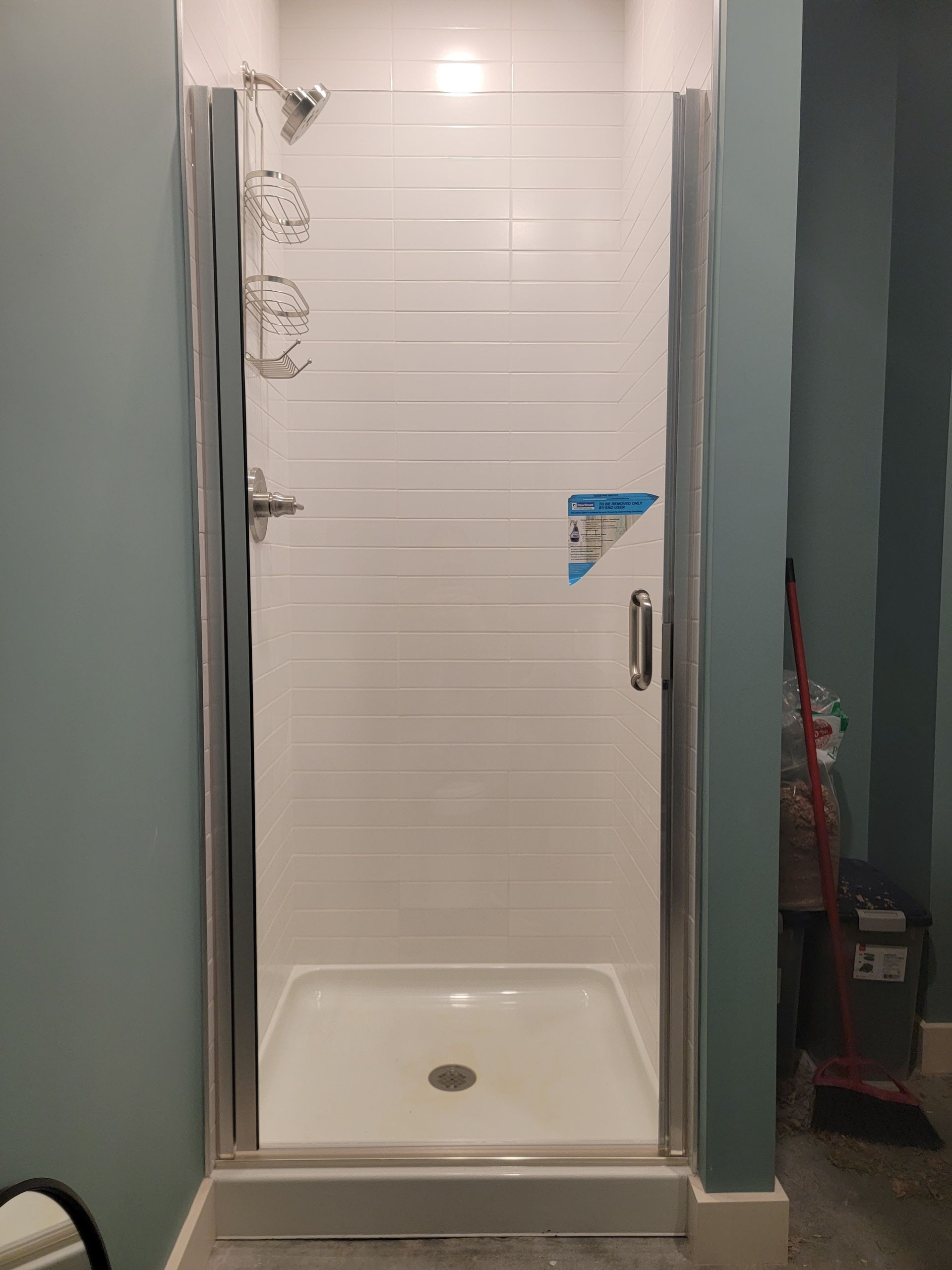 White shower with glass door in a bathroom with blue walls.