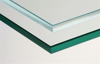 Two panes of glass, one clear and one green-tinted, stacked at an angle against a white background.
