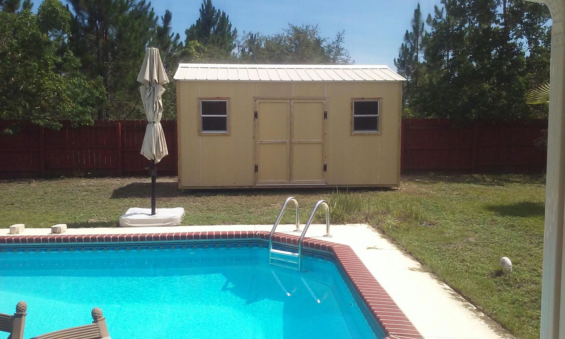 A shed sits next to a large swimming pool