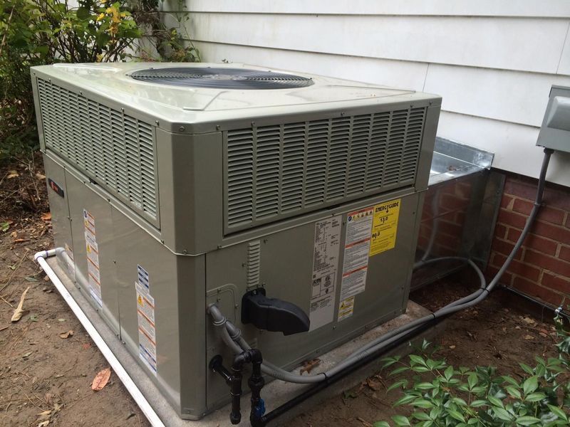 Outdoor air conditioning unit beside a brick wall.