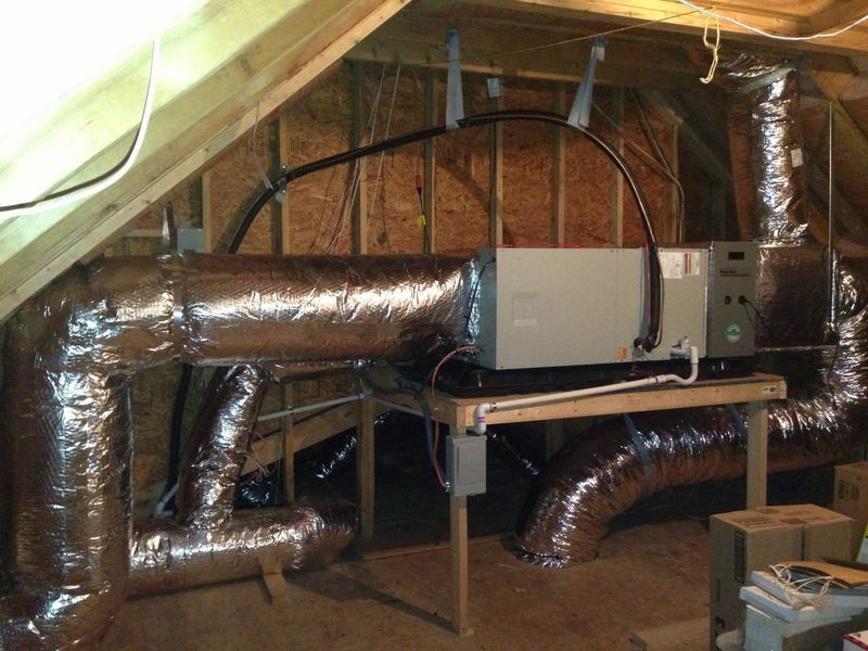 HVAC system installed in an attic; ductwork and unit on a wooden support structure.