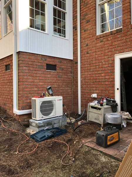 Brick building exterior with HVAC unit, generator, and tools.