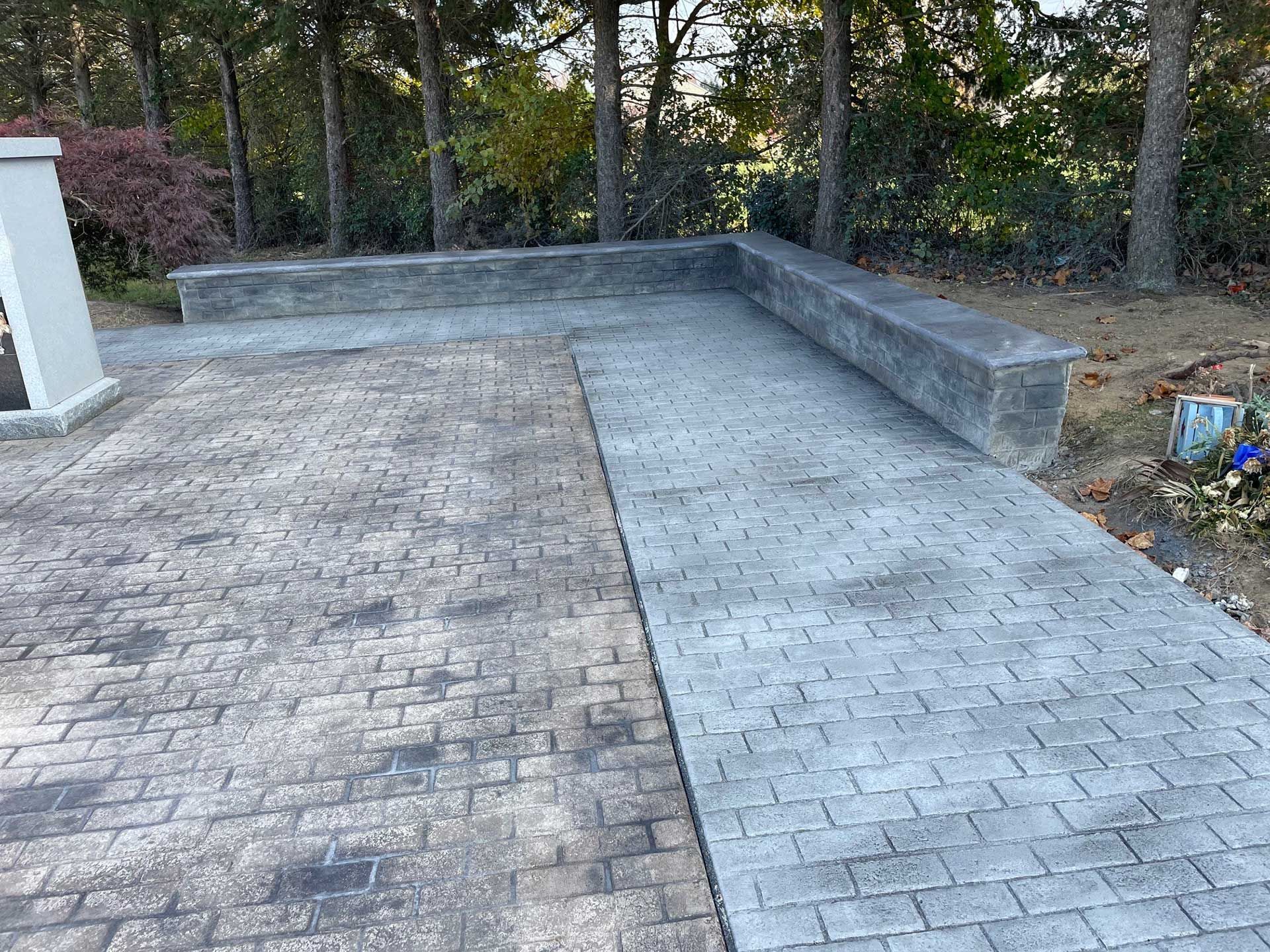 a stamped concrete walkway with a bench on the side of it