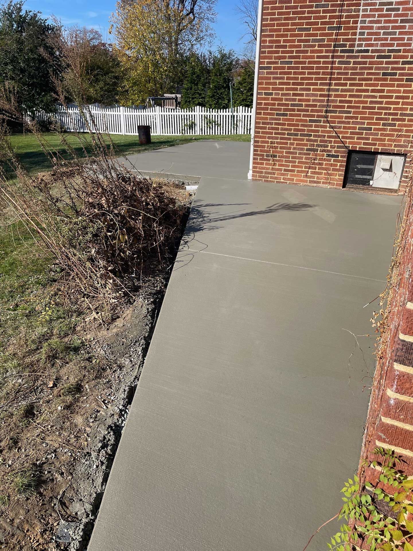 a brick building with a concrete walkway in front of it
