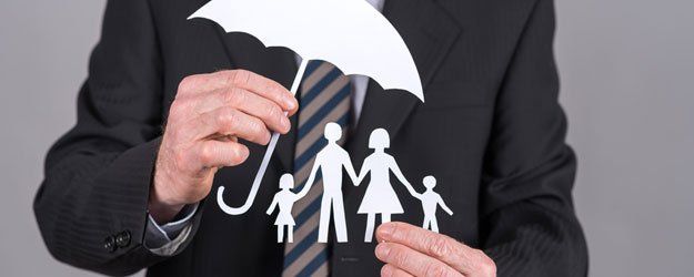 a man holding a paper illustration of family with umbrella