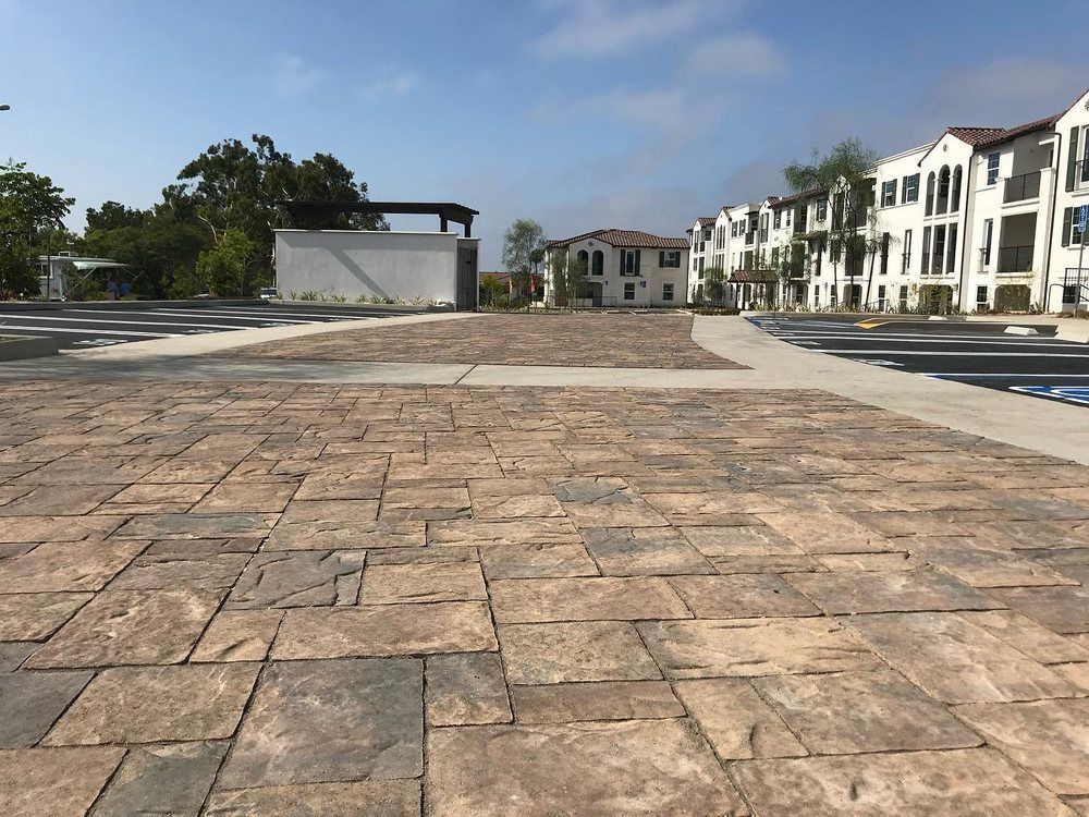 Empty stone plaza with white apartment buildings and blue sky