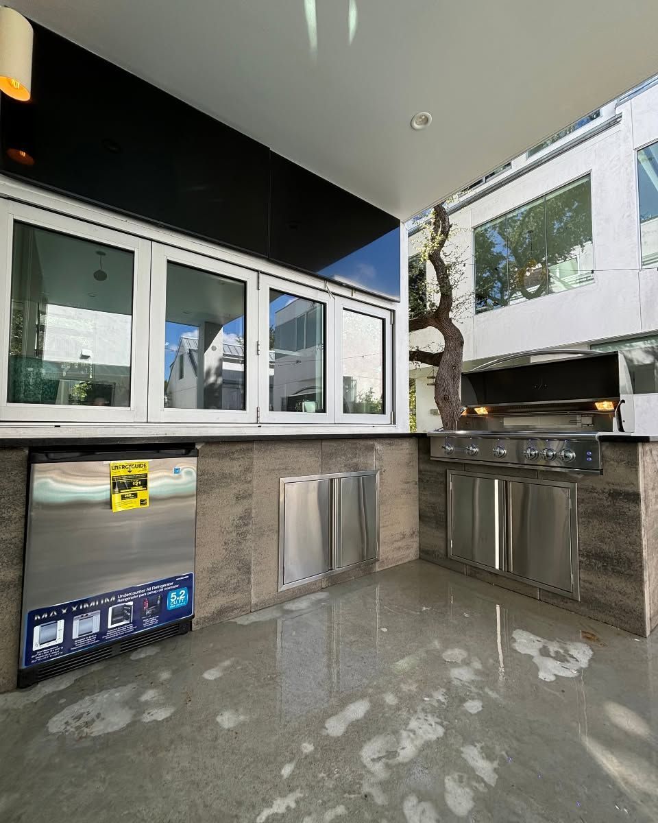 Outdoor patio with stainless steel counters, windows, and a wet reflective floor