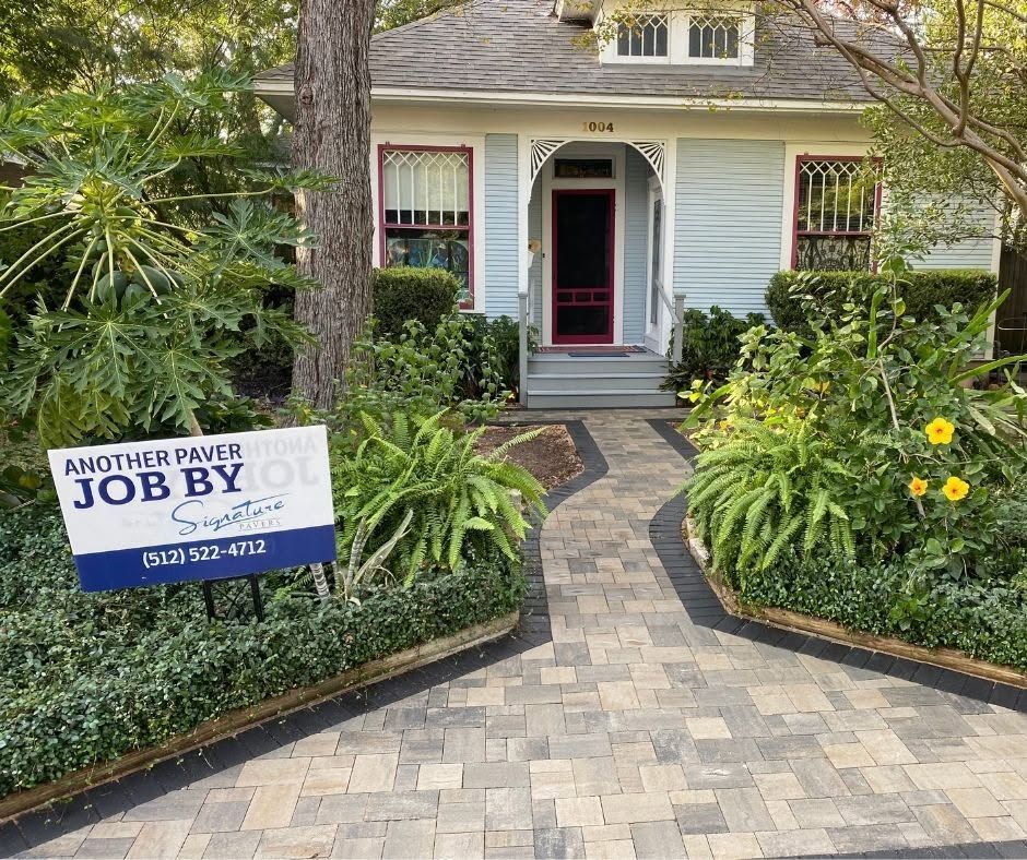 House with paved walkway and blue “Another Prayer Job By” yard sign in front yard