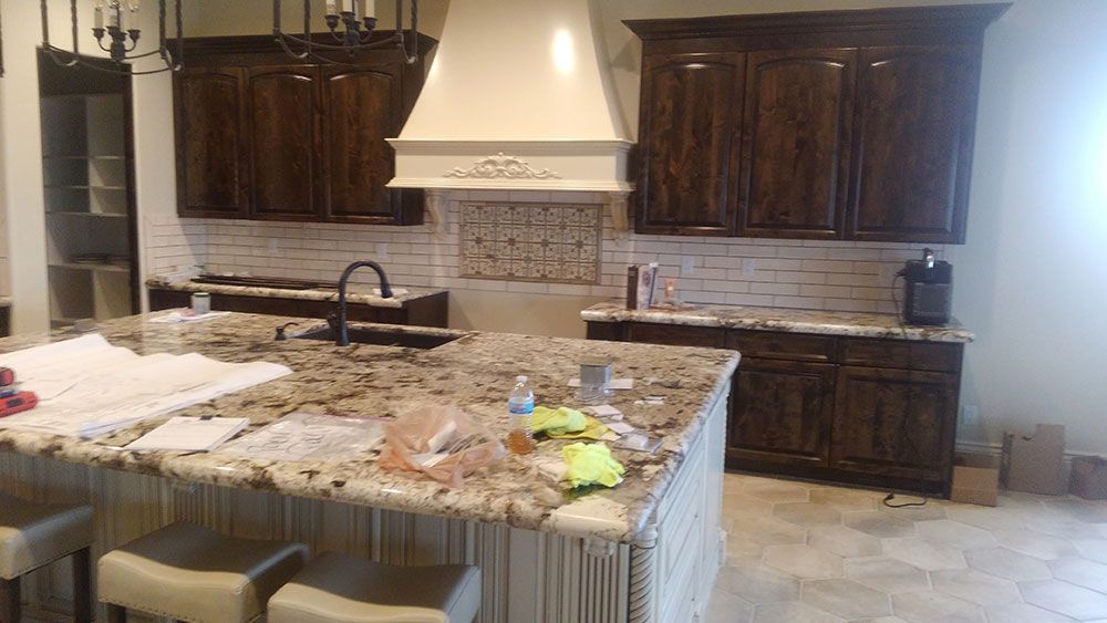 Kitchen with dark wood cabinets, granite countertops, and a white range hood.