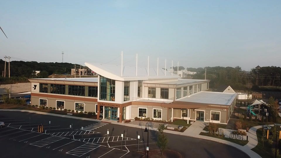 An aerial view of a large building with a parking lot in front of it.
