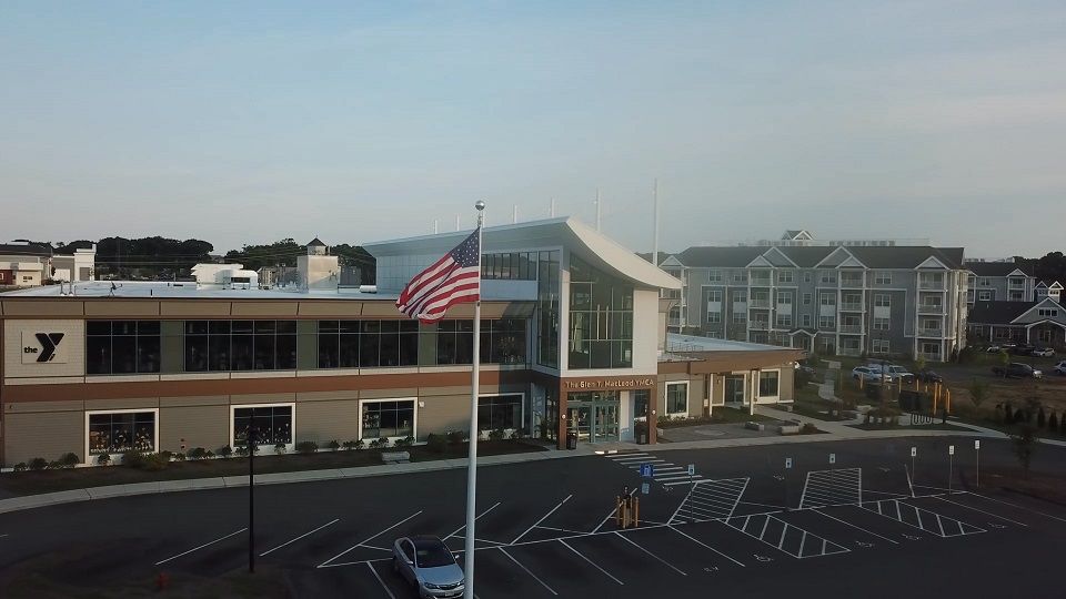 An aerial view of a building with an american flag flying in front of it.
