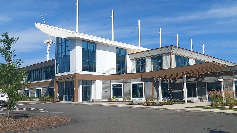 A large building with a lot of windows and a blue sky in the background.