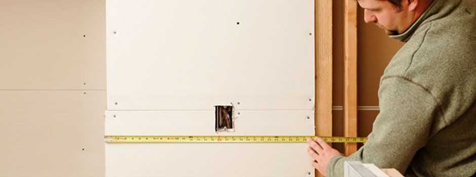 man measuring for drywall