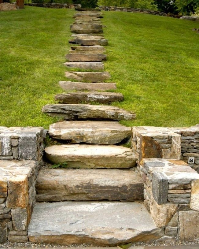 Stone steps lead up a grassy hill, with a stone wall at the base.