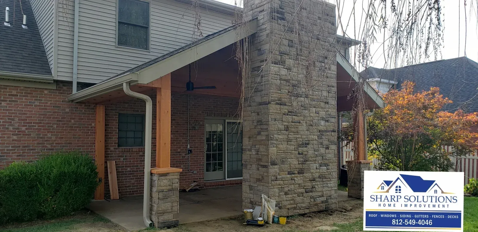 Apartment entrance with brick and stone exterior, covered entry, and a sign for a security company