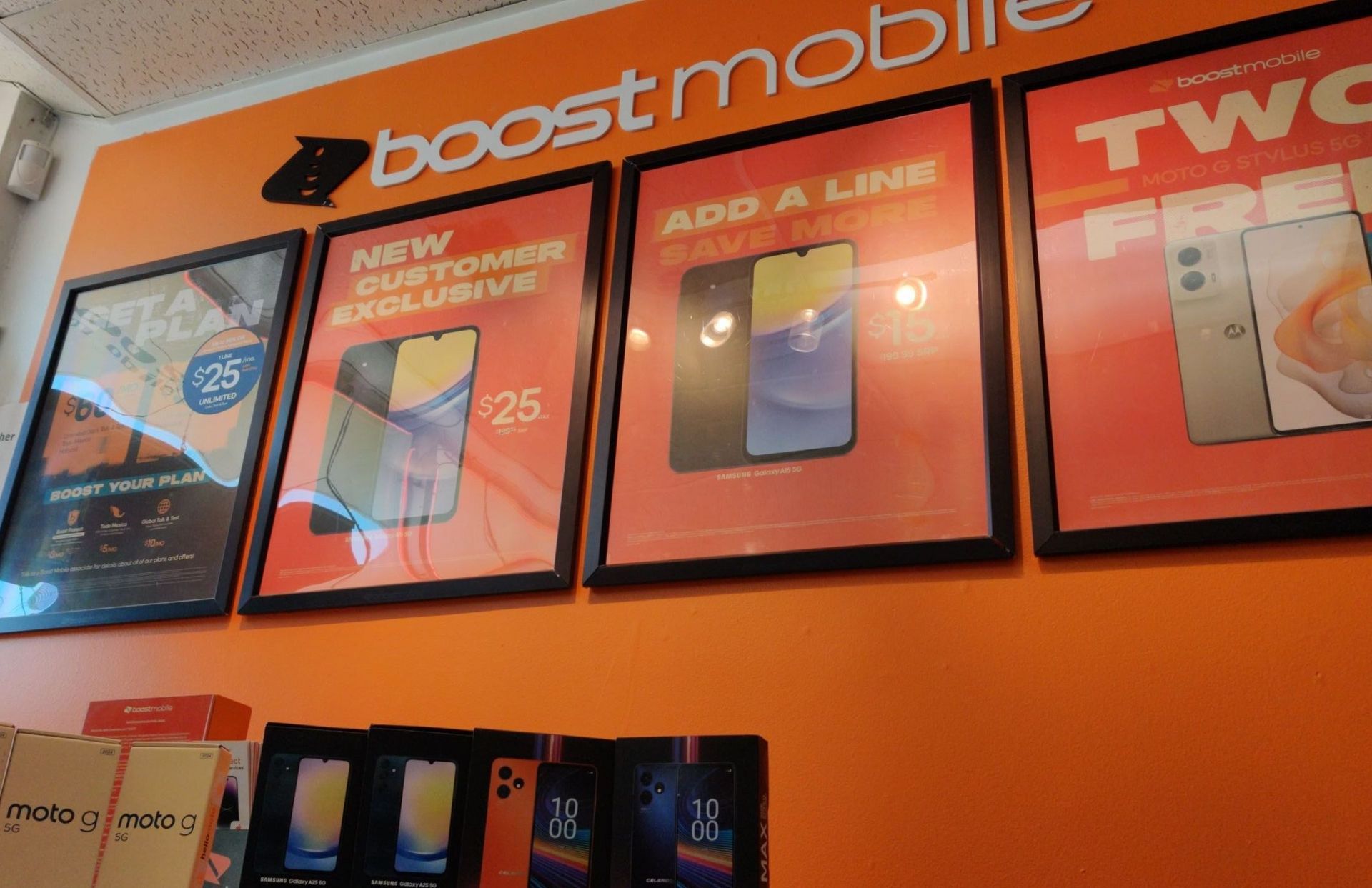 A bunch of posters on a wall that say boost mobile