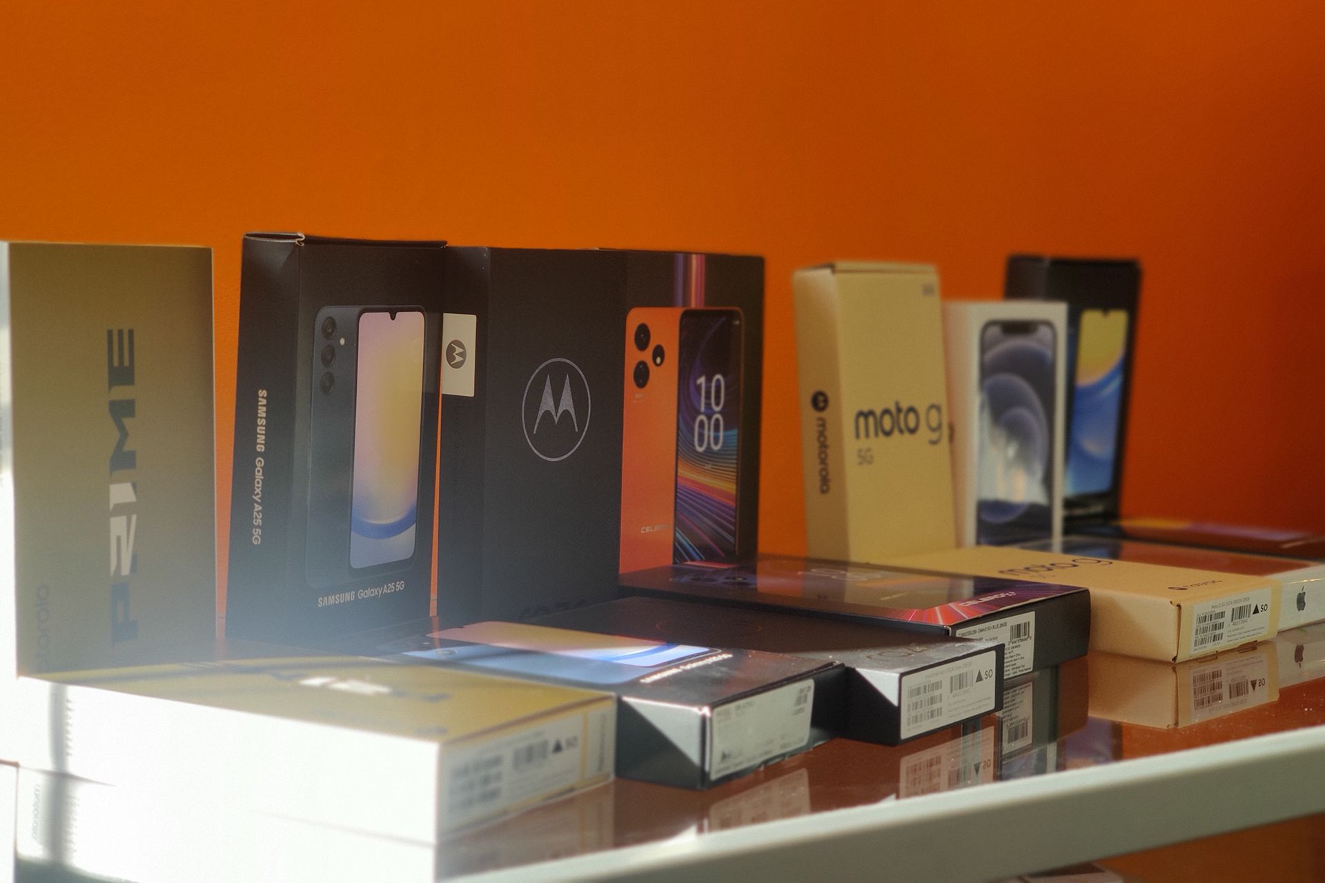 A row of cell phones sitting on top of each other on a table.