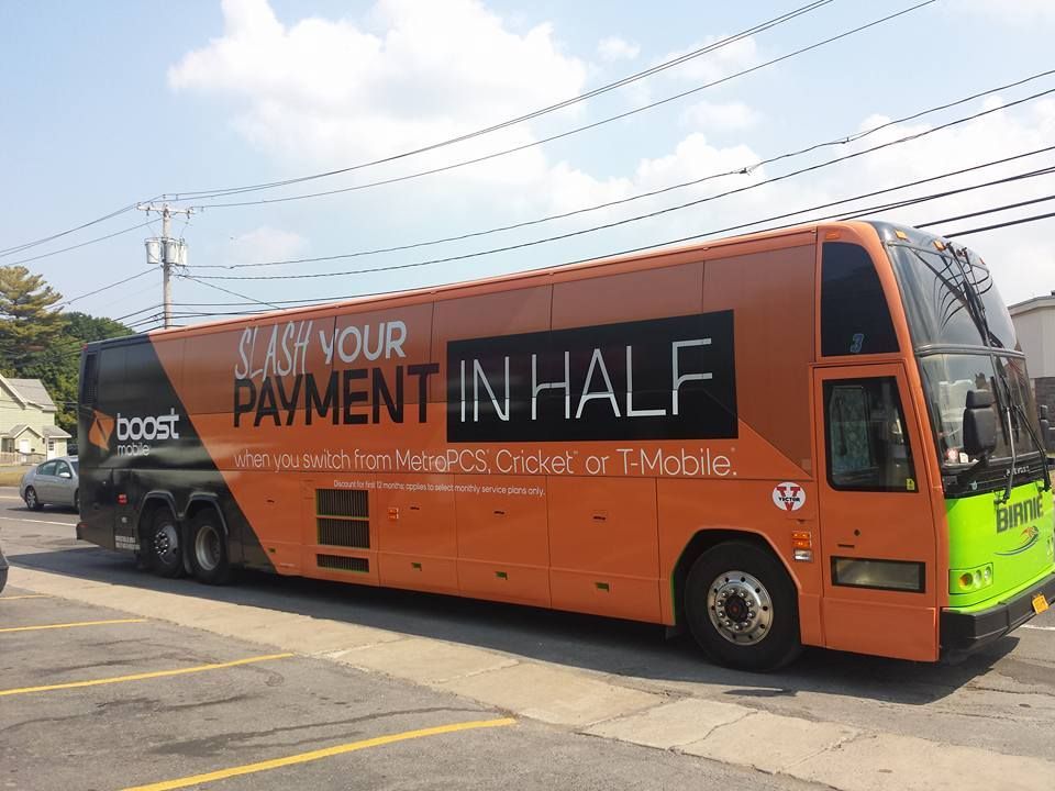 An orange double decker bus that says pay your payment in half