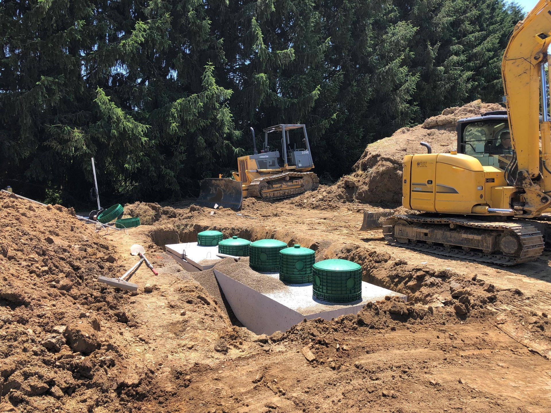 A construction site with a yellow excavator and a bulldozer