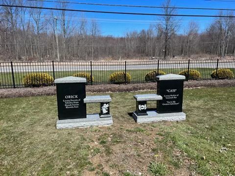 A black gravestone with a cross on it.