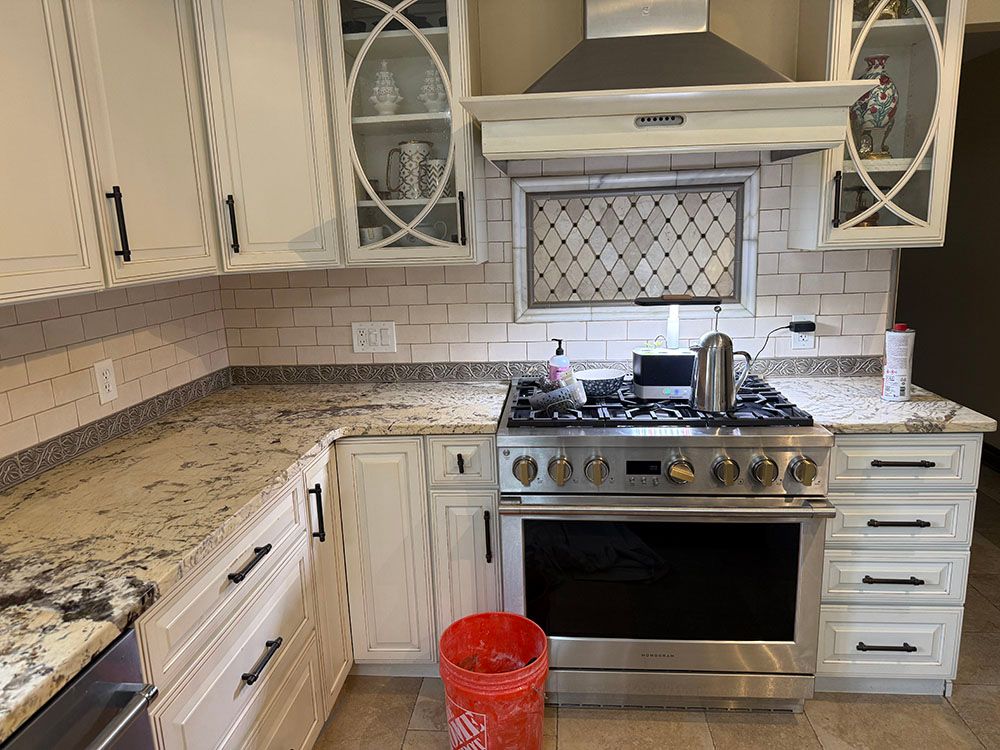 A kitchen with stainless steel appliances and white cabinets