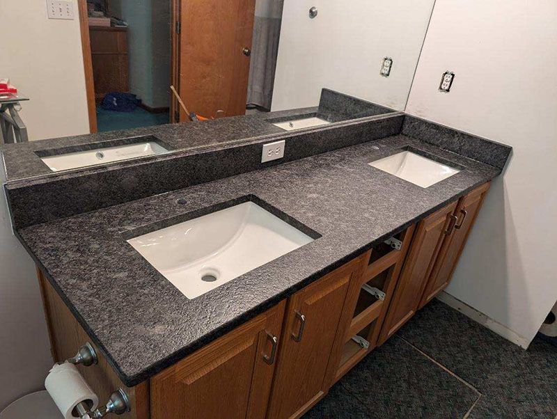 A bathroom with two sinks and a large mirror.