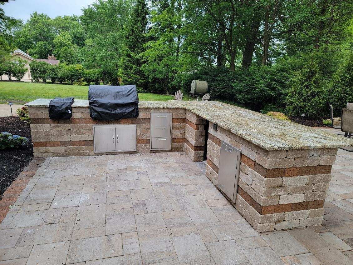 A large outdoor kitchen with a grill and a bar.