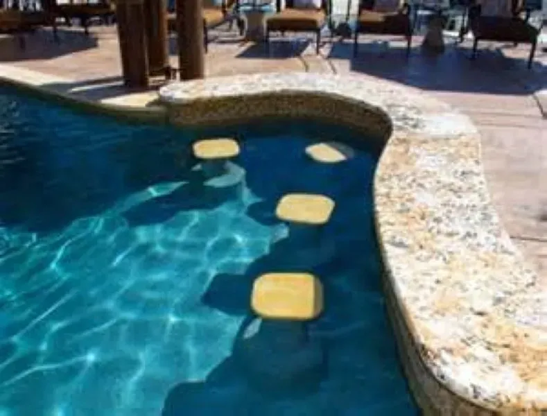 A swimming pool with stepping stones in the water.
