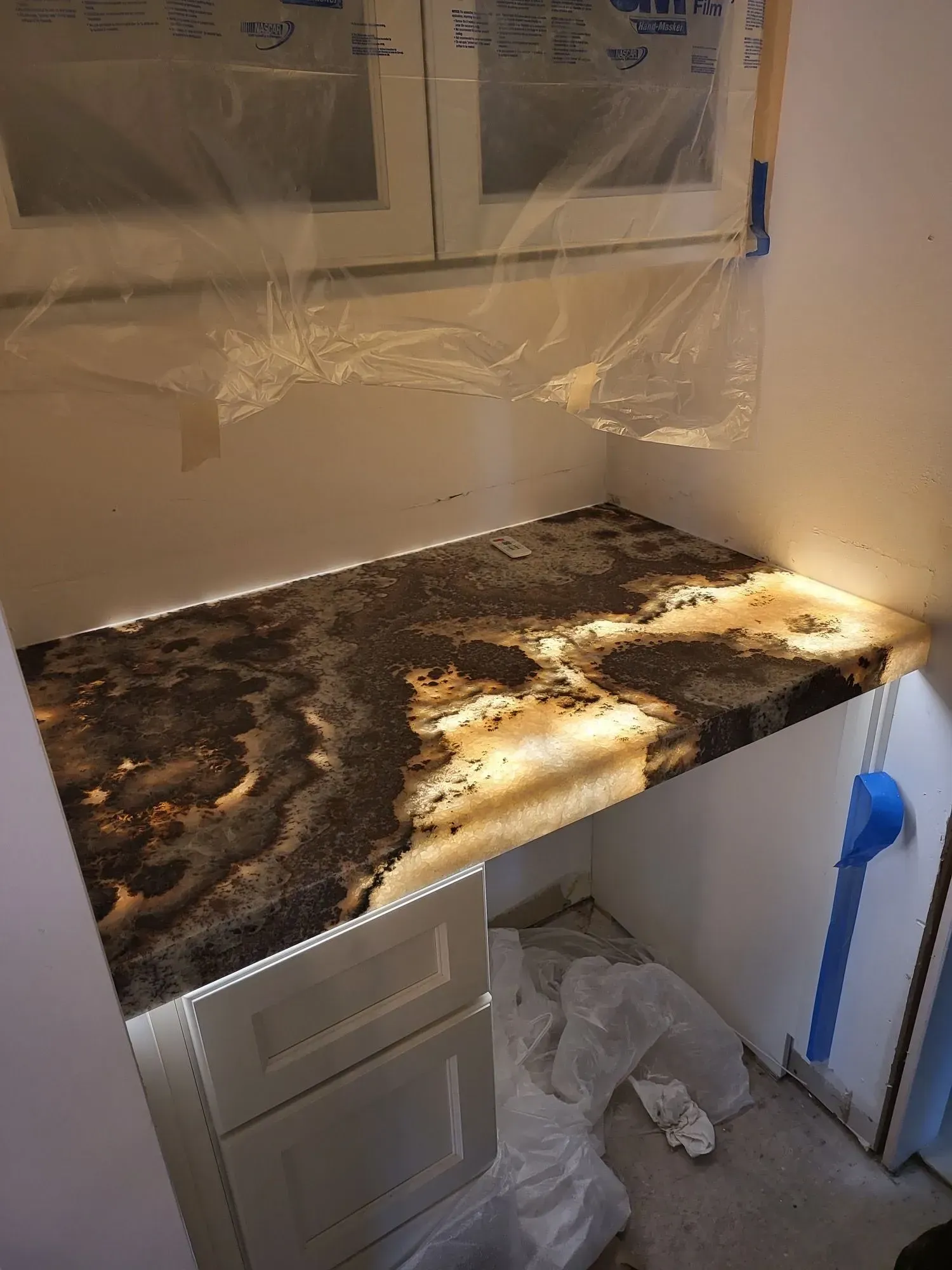 A kitchen with a granite counter top and white cabinets.