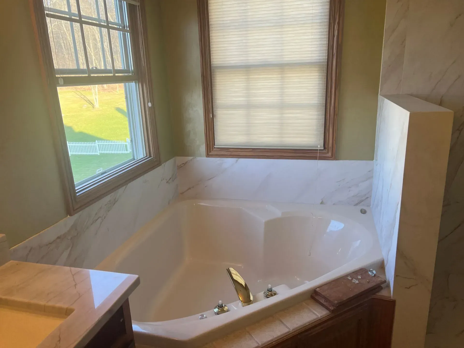A bathroom with a jacuzzi tub and a window.