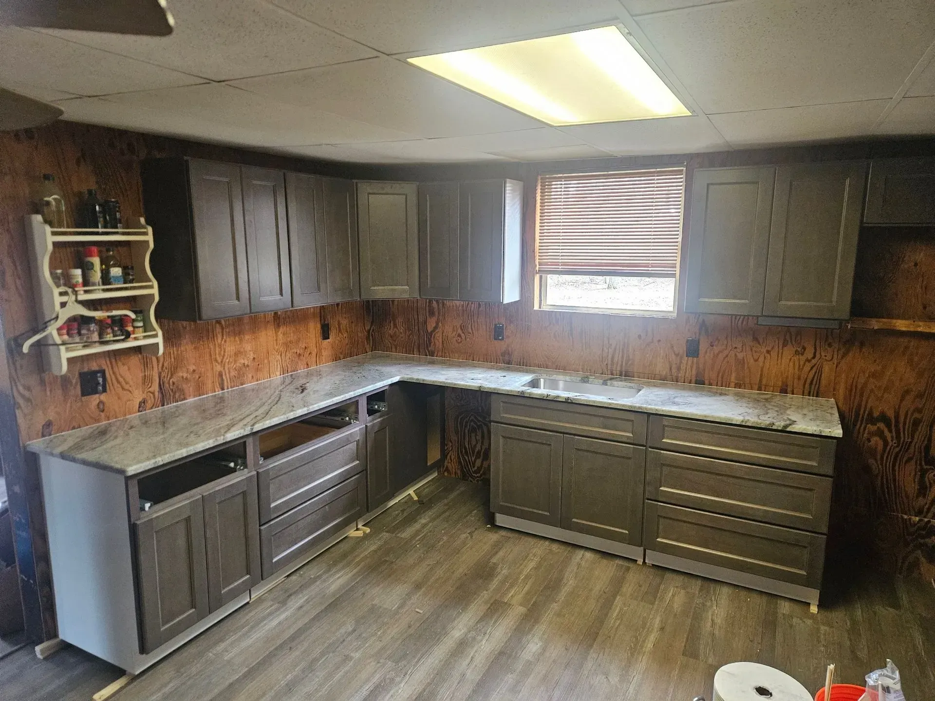 A kitchen with gray cabinets and granite counter tops is being remodeled.
