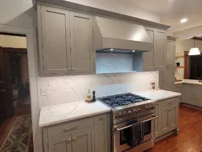 A kitchen with stainless steel appliances and gray cabinets.
