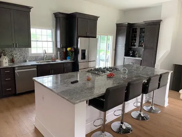 A kitchen with a large island and stools.
