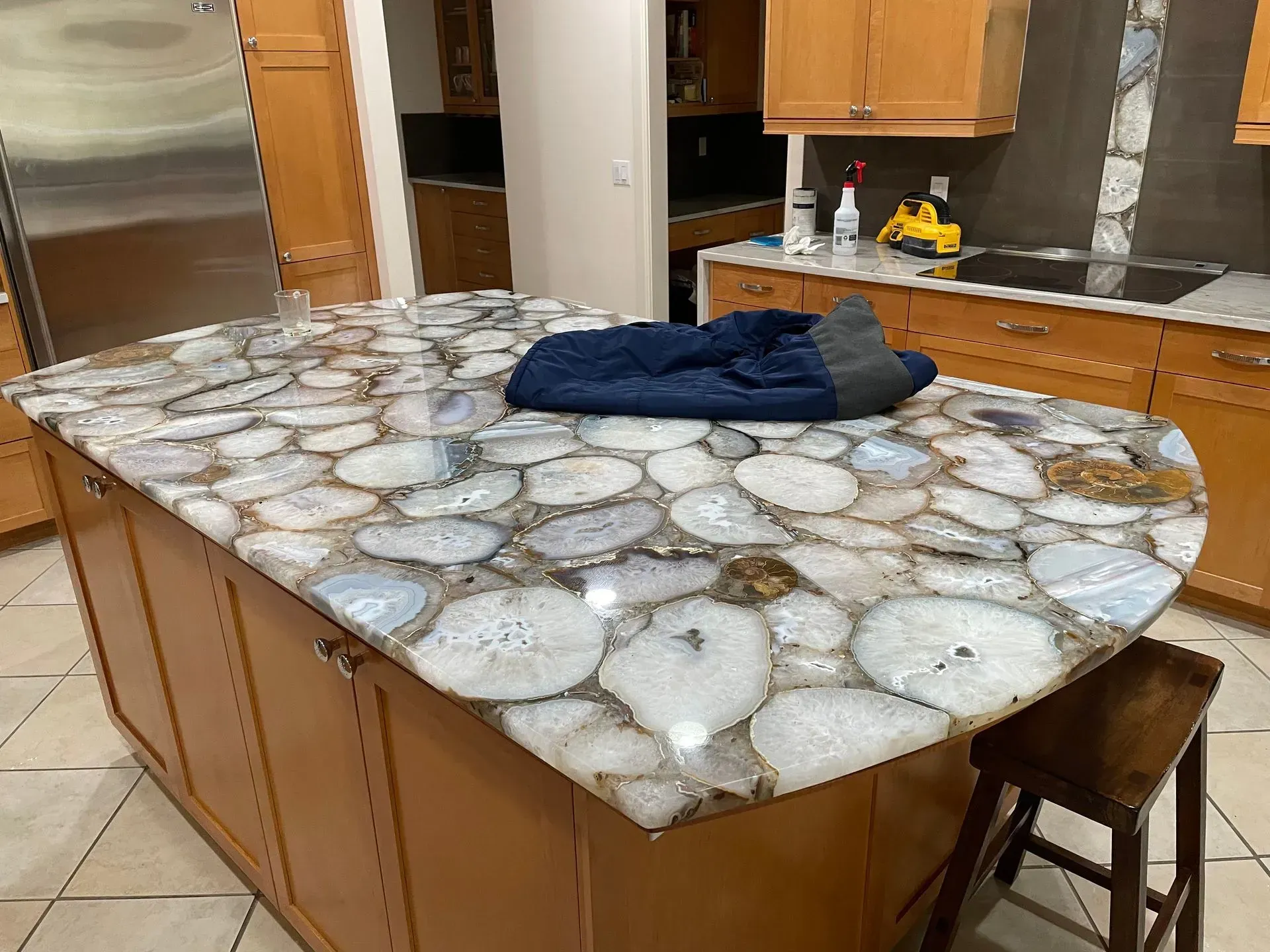 A kitchen with a large granite counter top and wooden cabinets.