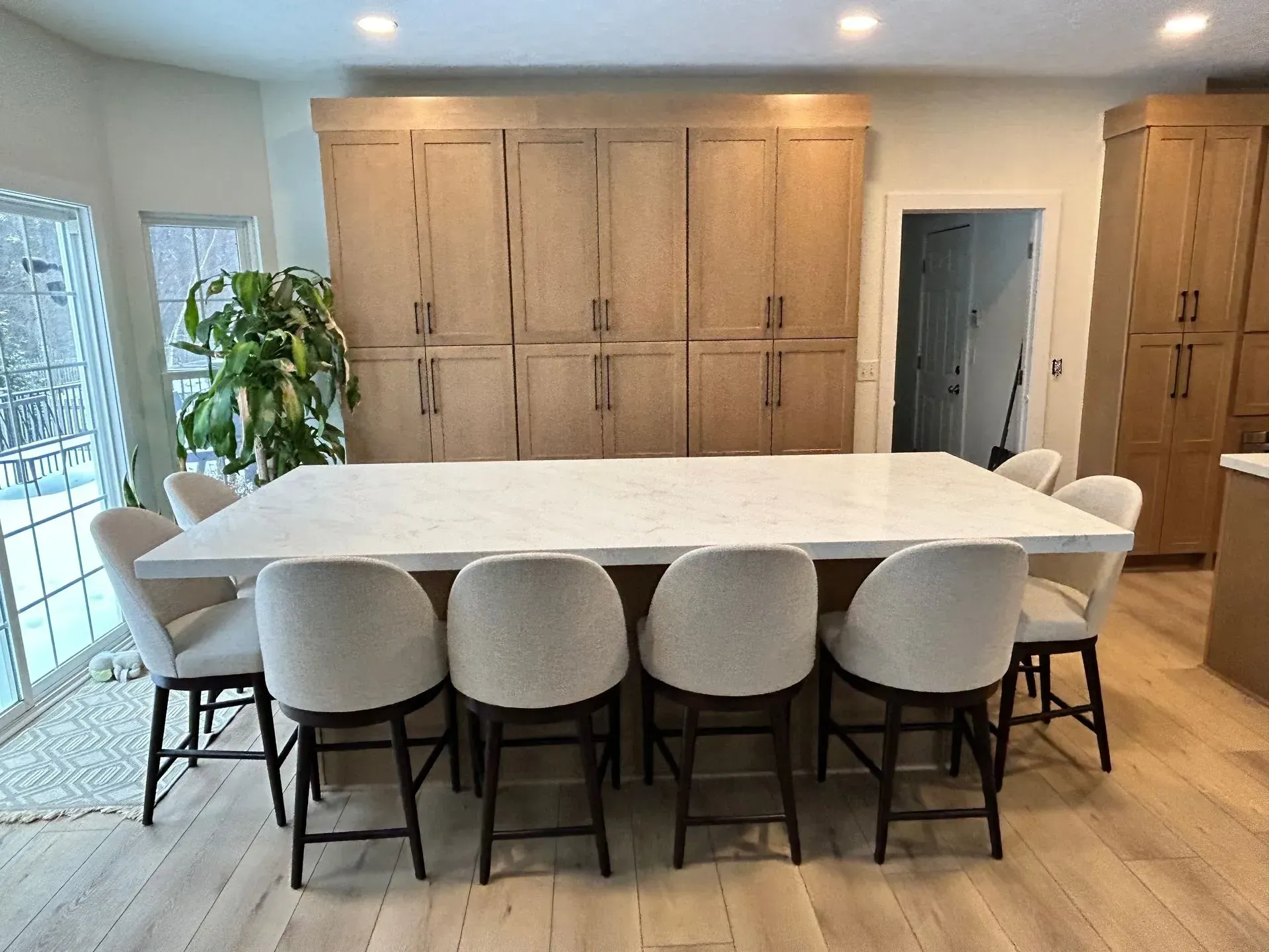 A kitchen with a long table and chairs in it.