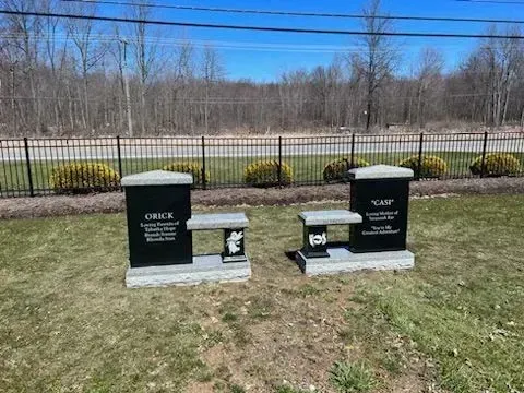 A black gravestone with a cross on it.