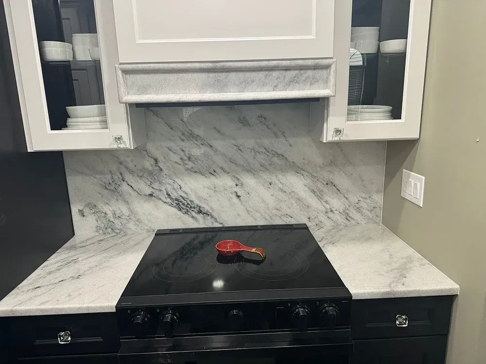A black stove top oven is sitting on top of a white counter in a kitchen.