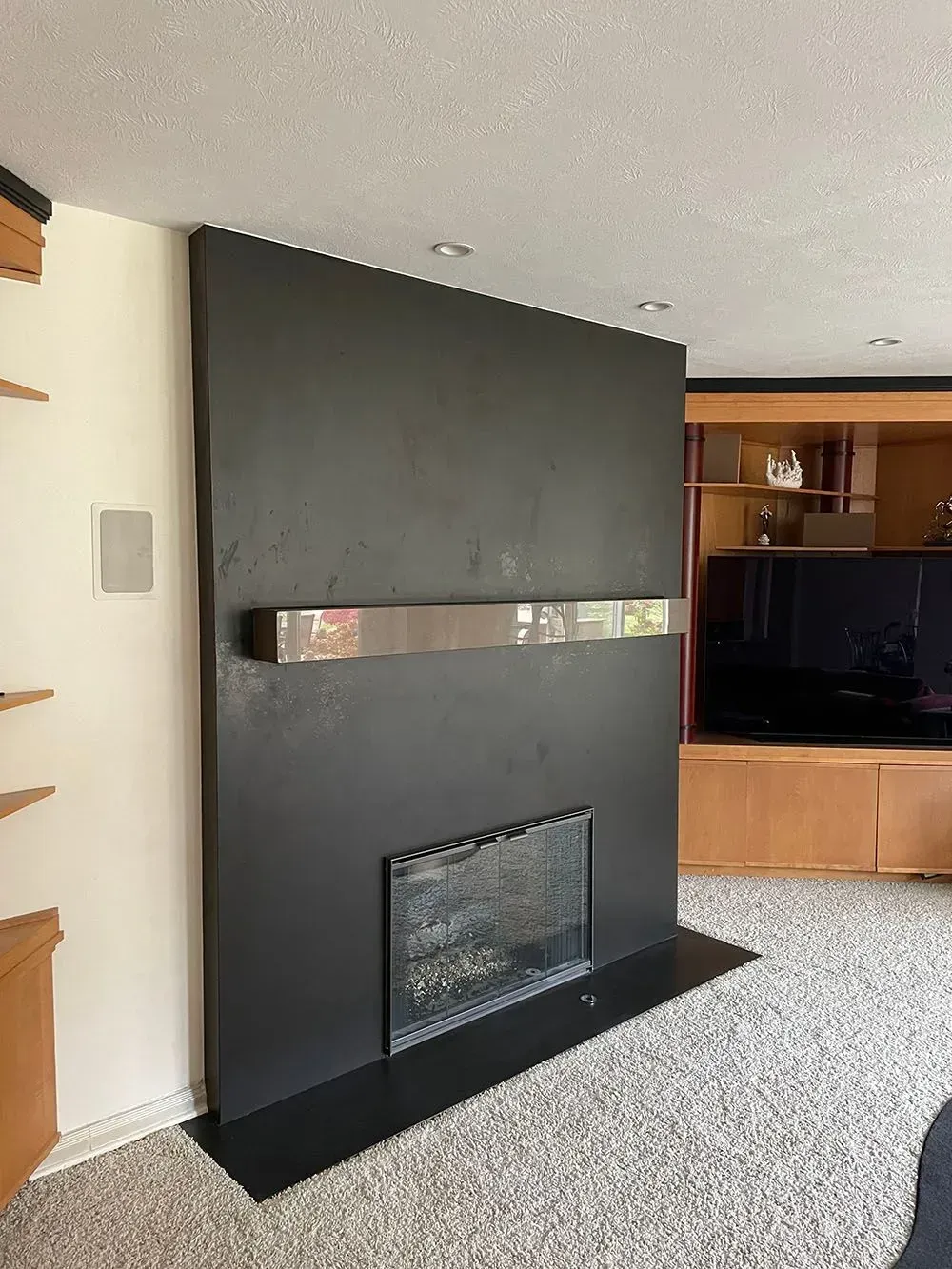 A living room with a black fireplace and a flat screen tv.