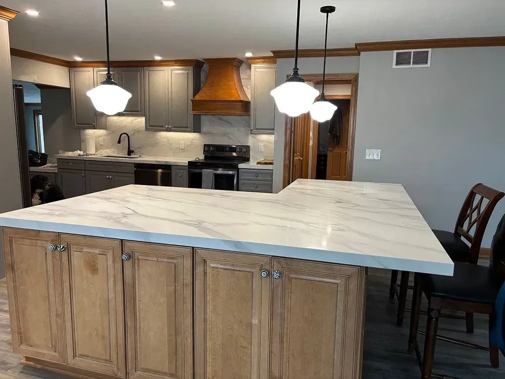 A kitchen with wooden cabinets and a marble counter top