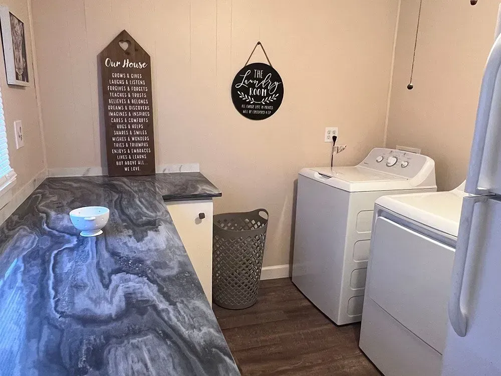 A laundry room with a washer and dryer and a refrigerator.