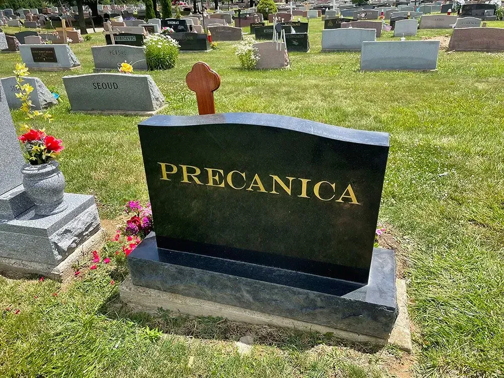A black gravestone with the name precanica on it.