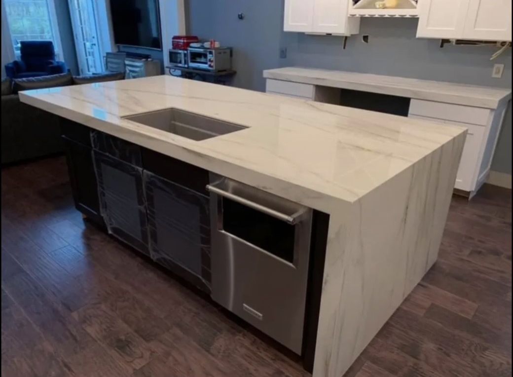 A kitchen with a large island and a sink.