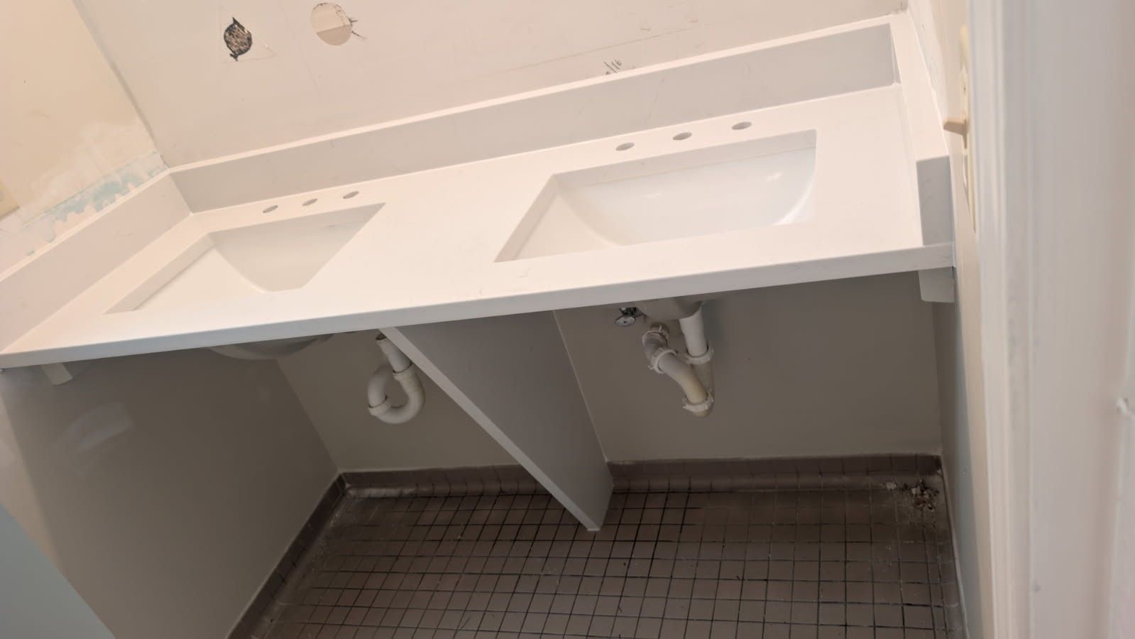 A bathroom with two sinks and a tiled floor.