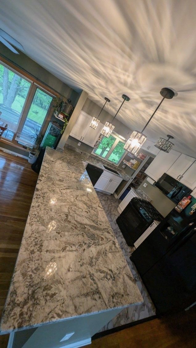 A kitchen with granite countertops and a large island.