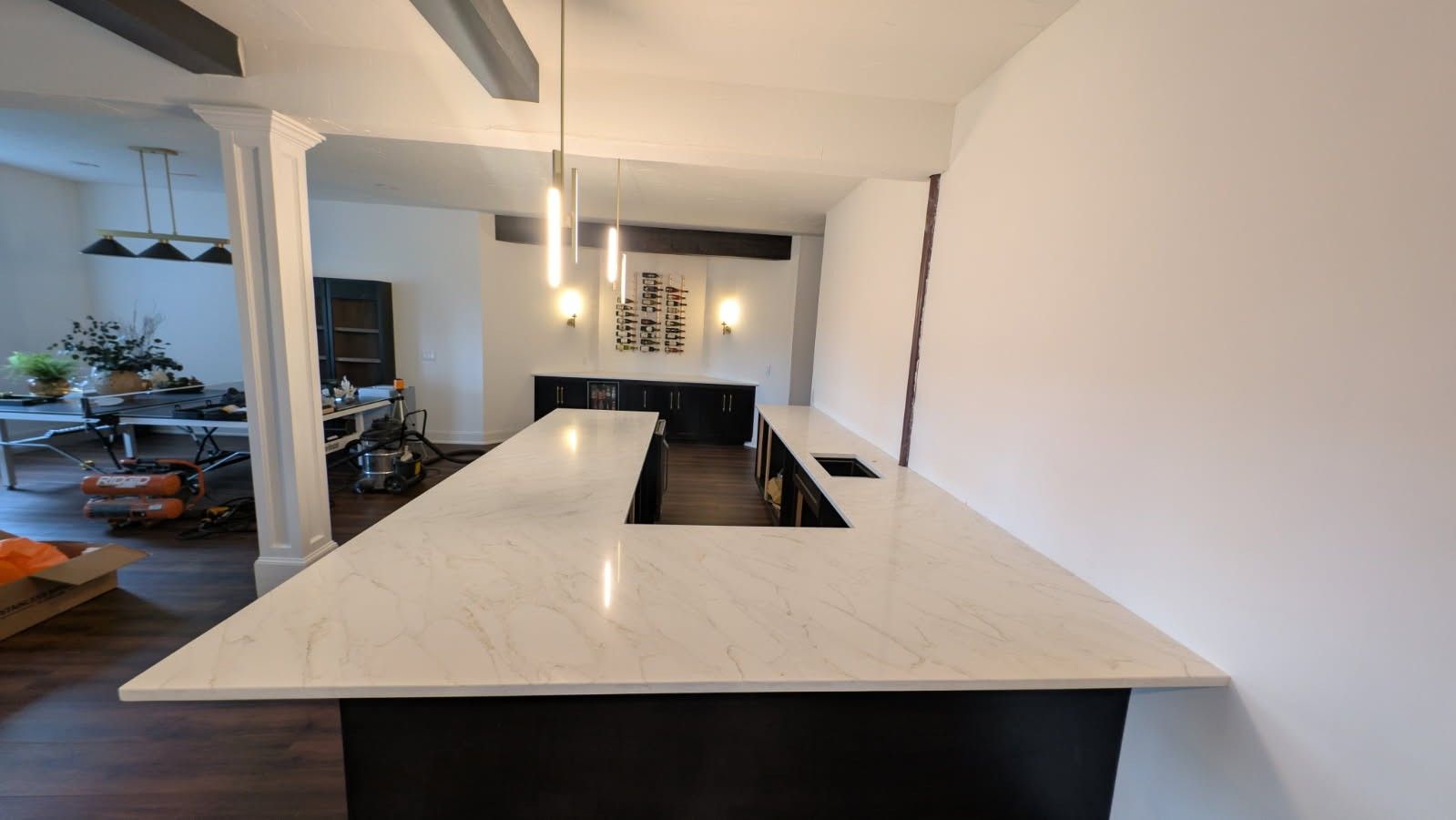 A kitchen with a long countertop and a sink.