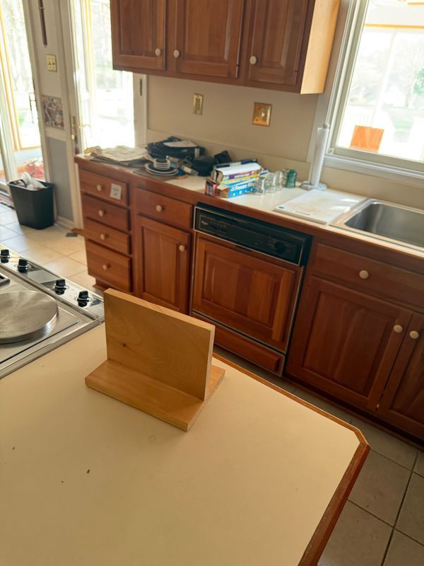 Kitchen with wood cabinets and appliances. A wooden block sits on the countertop in the foreground.