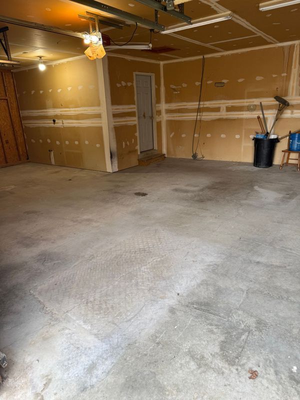 Empty garage with concrete floor and unfinished walls.