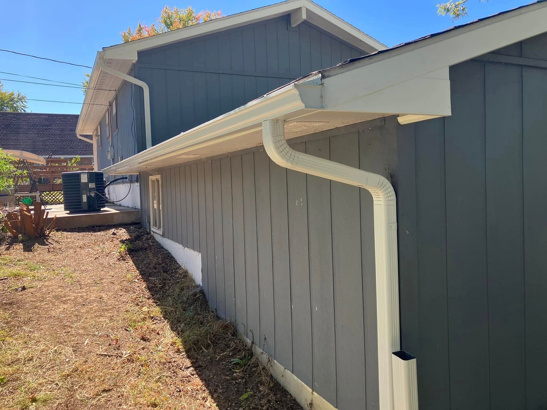 A house with a white gutter on the side of it.